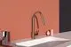 Rotgoldene Küchenarmatur von Ideal Standard, mit schlankem Design, freistehend über einem weißen Spülbecken, vor einem hellen Wandhintergrund.